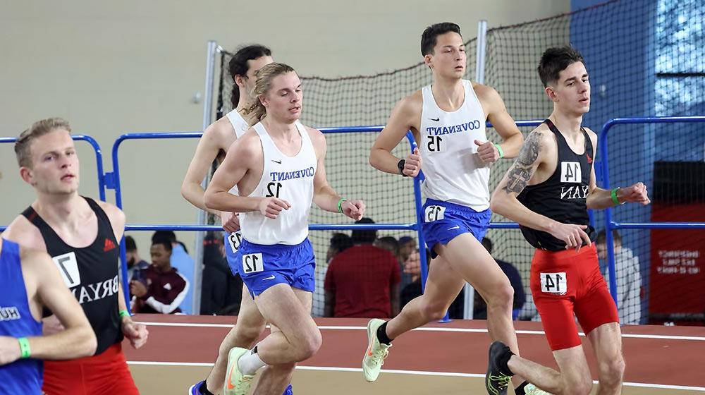 male track and field athletes running on indoor track